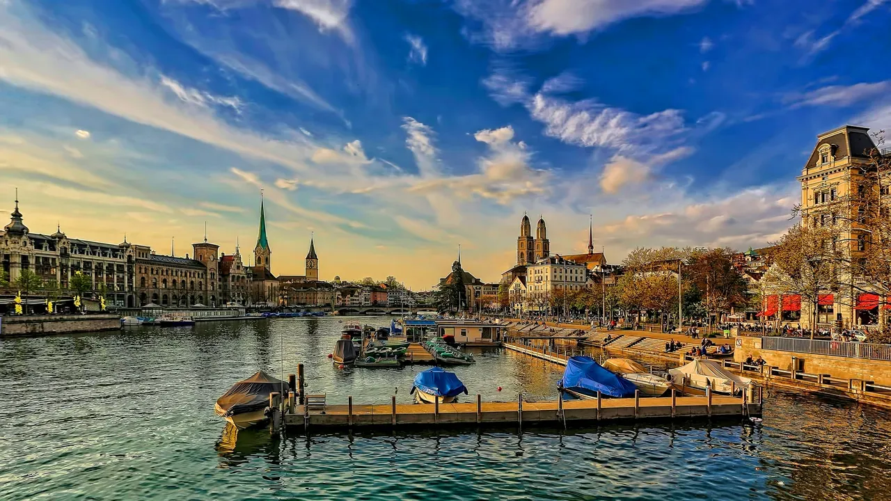 The Limmat riverfront in Zurich, boats at a jetty and the twin towers of the Grossmünster above the old town