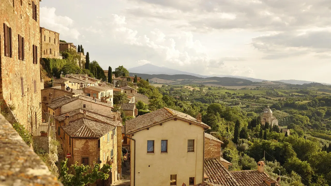 Een Toscaans heuveldorp met stenen huizen en pannendaken, met uitzicht over wijngaarden en glooiende heuvels