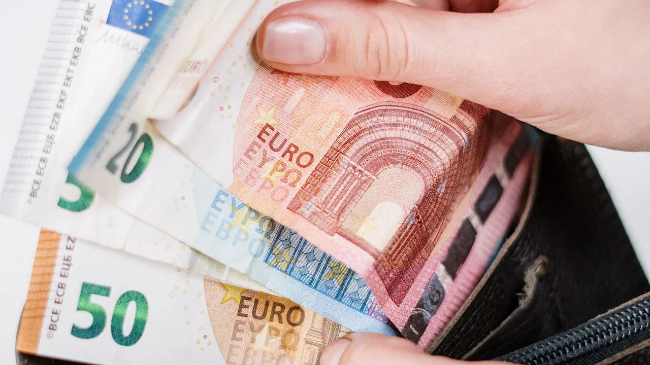 A hand pulling euro banknotes from a wallet