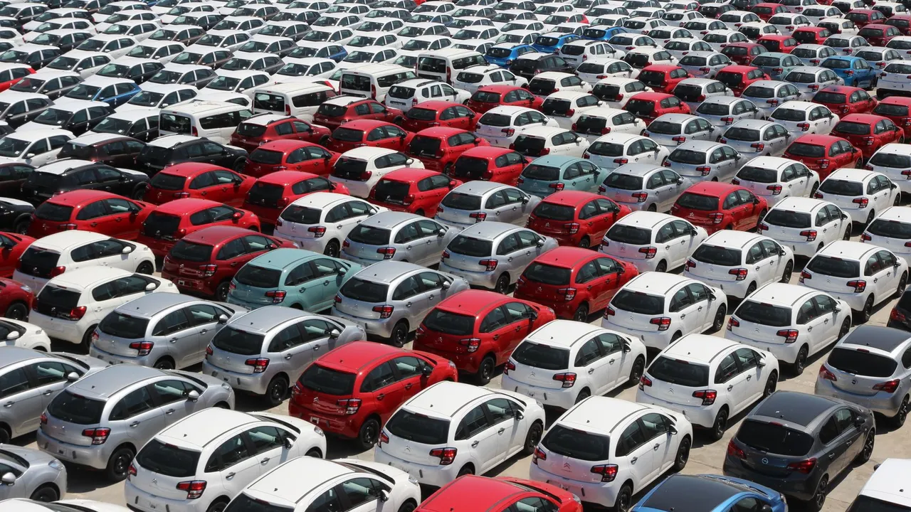 A high-angle view of a large car park filled with different passenger vehicles