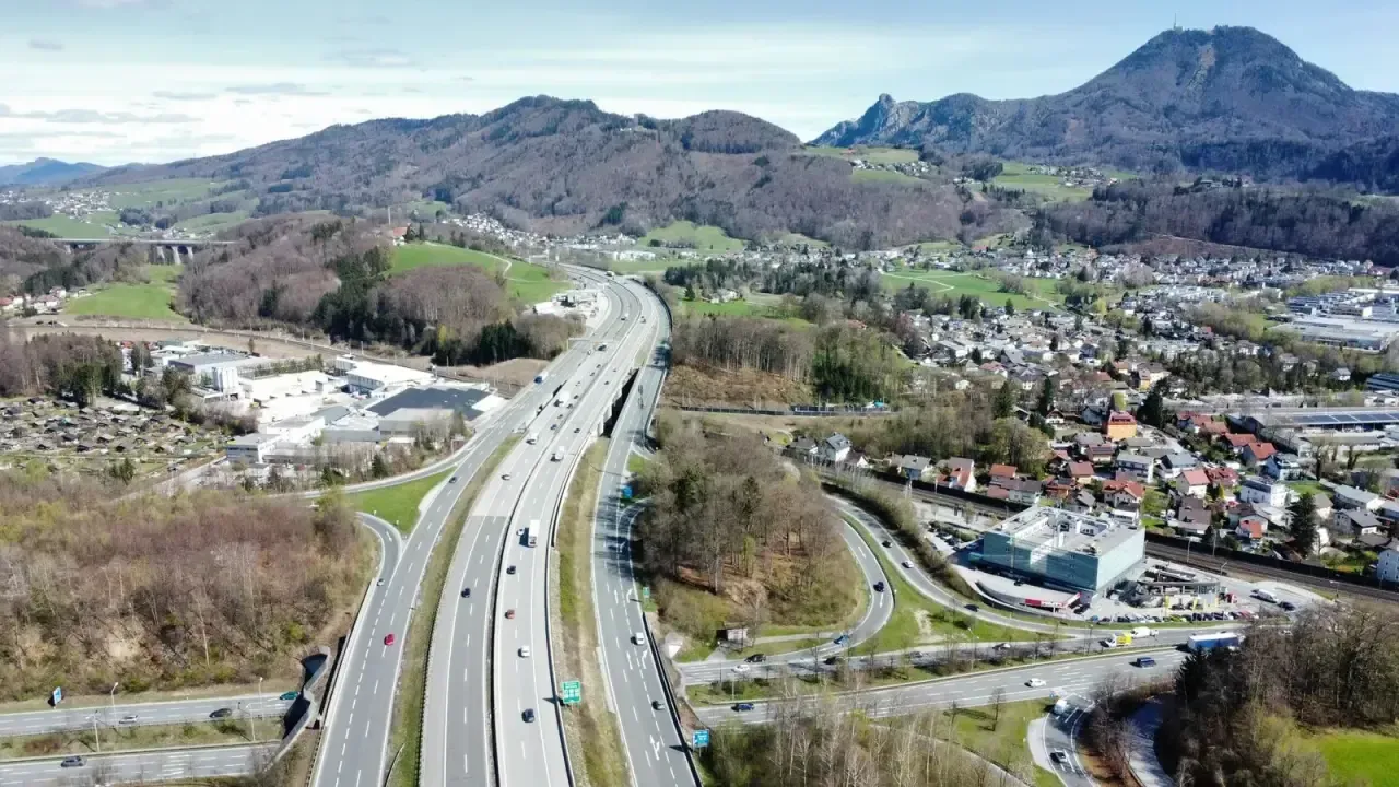Luchtfoto van de Oostenrijkse A1-snelweg die door groene heuvels bij Salzburg slingert